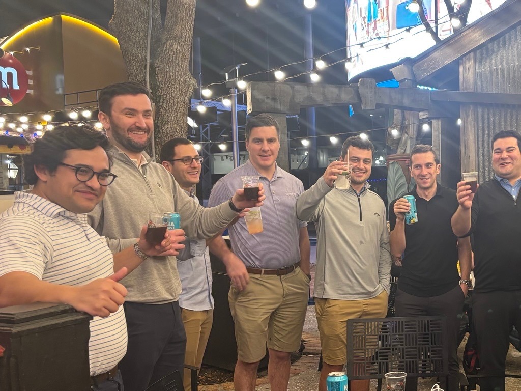 Waylin Partners team members raising drinks at an outdoor venue